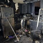 Burned kitchen with severe fire damage and debris.