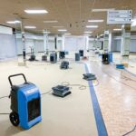 Empty store with dehumidifiers and fans operating.